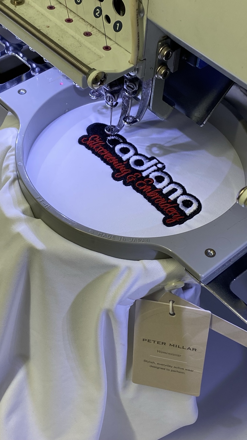 Acadiana embroidery in progress with the complete Peter Millar hang tag visible